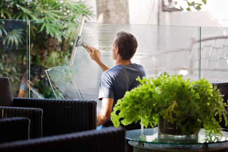 muž umývající okno