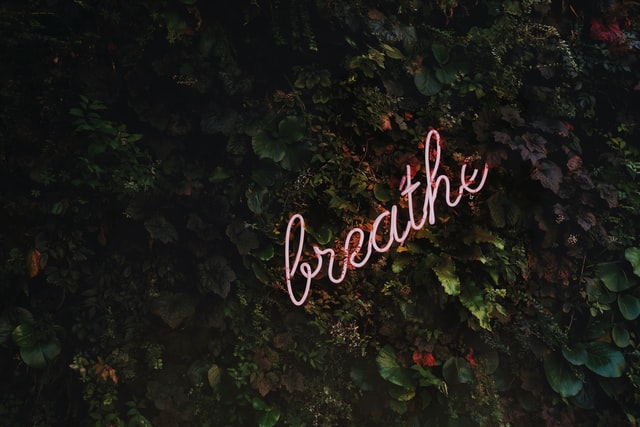 Svítivý nápis "breathe" na tmavém pozadí